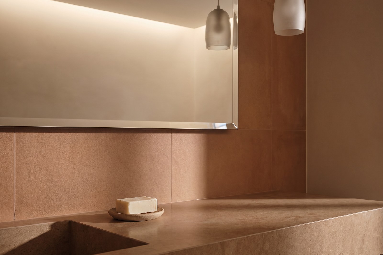 Pia de banheiro brasileira quase vazia, um sabão, luz baixa, sem kit de spa.